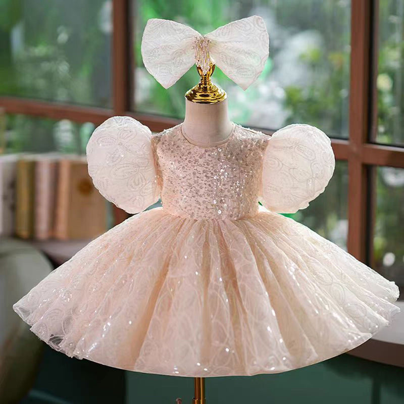 Pink lace flower girl dress in a knee-length silhouette for outdoor wedding styling