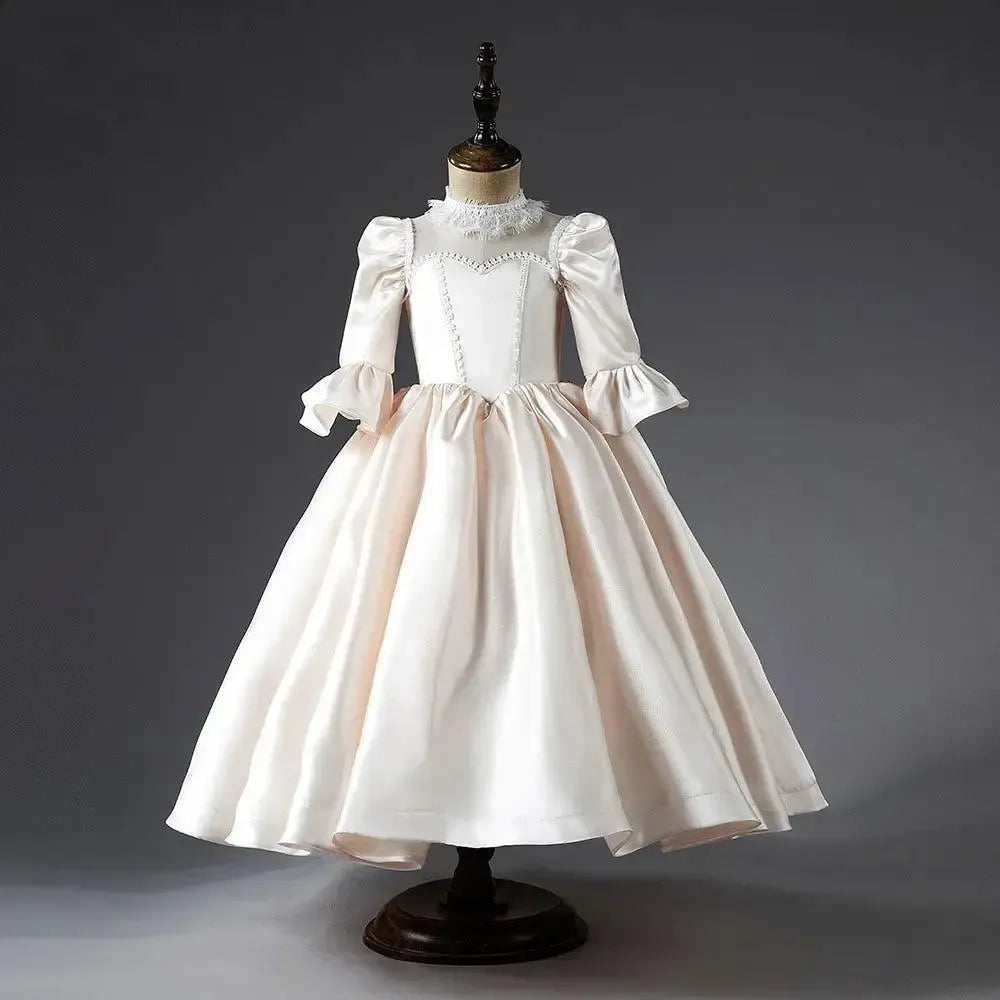 Ivory satin flower girl dress with high neckline and full formal skirt
